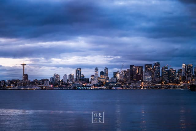 city skyline, water, cloud-filled sky, light reflections, observation tower