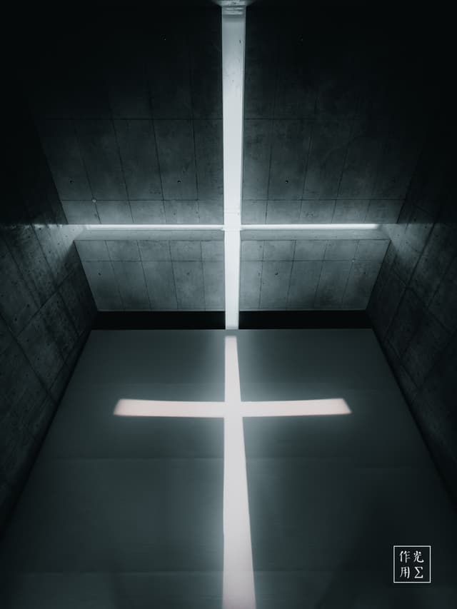 A brilliant cross of light slices through the heavy concrete walls, its horizontal beam hovering like a spectral arm and its vertical shaft plunging into shadow. The raw, monolithic surfaces suck away warmth, leaving only the searing white glow to carve an almost sacred geometry in the darkness. Stark angles and cool gray tones amplify a hushed, otherworldly tension—an austere sanctuary forged from light and stone